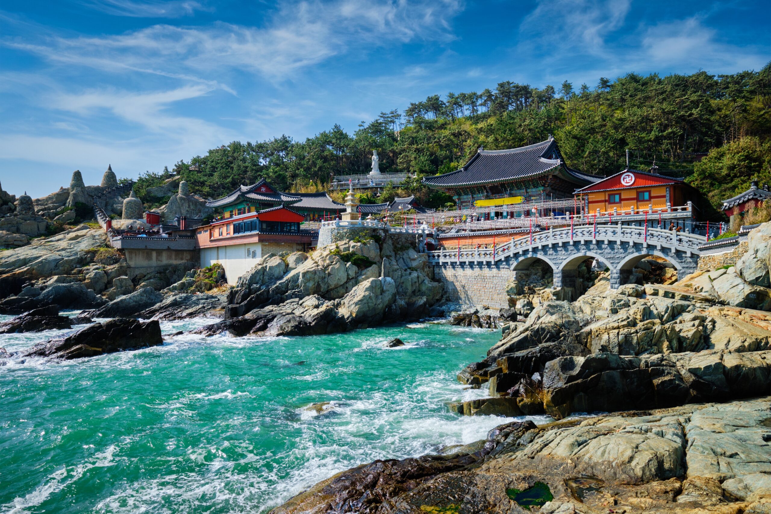 Colorful Seaside Temple Complex Built on Rocky Cliffs with a Stone Bridge